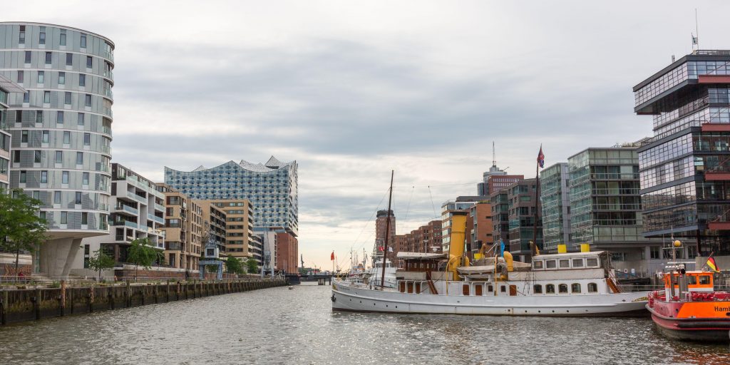2C84271 View along the Sandtorhafen towards the Elbphilharmonie. Cityscape of the Hamburg Hafencity with modern buildings and boats.